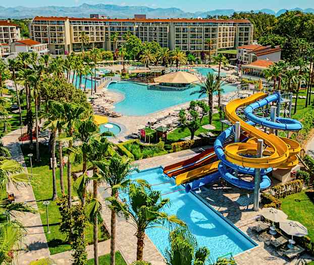 Et feriested med flere bassenger, grøntområder og vannsklier. (AI-generert tekst)