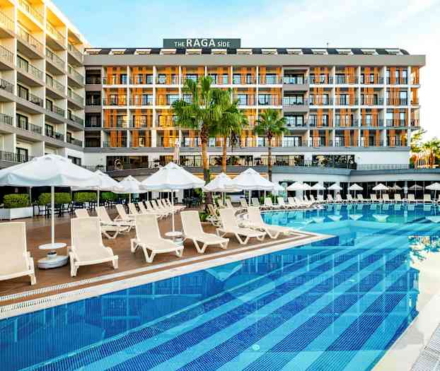 Et hotell ved et basseng med solsenger og parasoller. (AI-generert tekst)