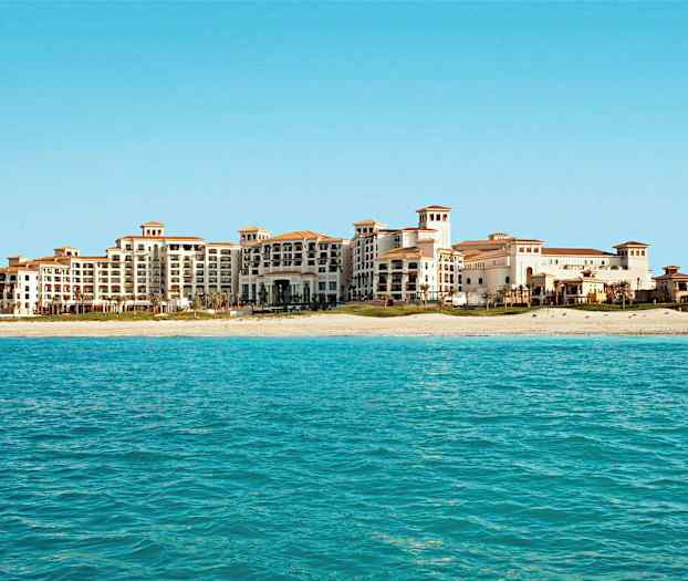 Hotellkompleks med strand og hav. (AI-generert tekst)