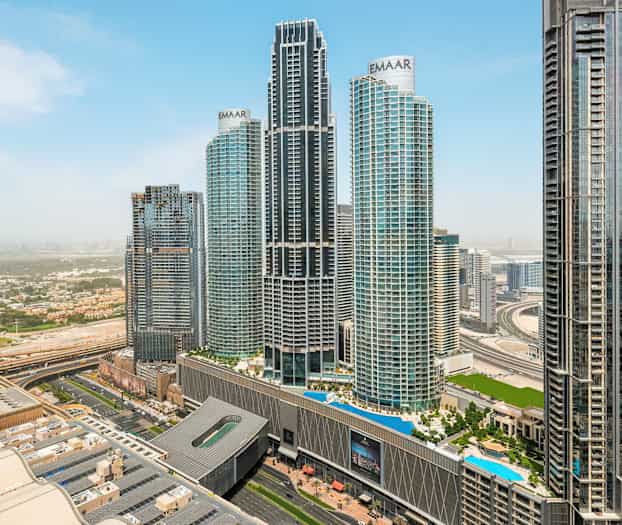 En bybilde med flere høye skyskrapere og en motorvei i forgrunnen. (AI-generert tekst)