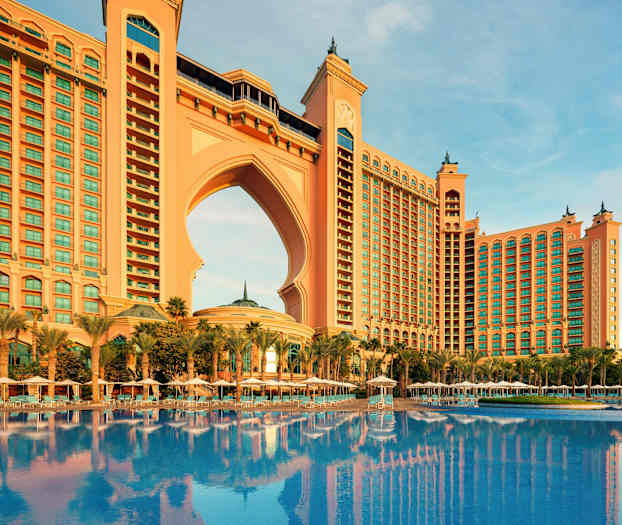 Stor bygning med bue og basseng foran. (AI-generert tekst)