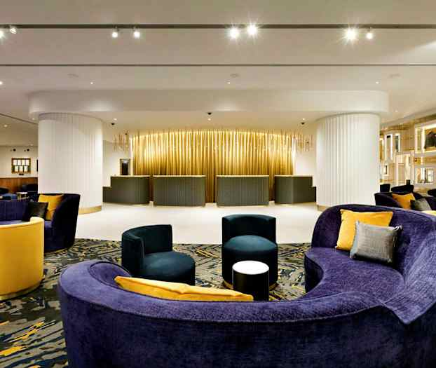 Hotellresepsjonen med moderne møbler og varm belysning. (AI-generert tekst)