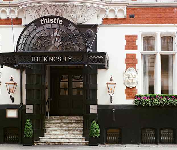 Hotellinngang med trapper, skilt og blomster. (AI-generert tekst)