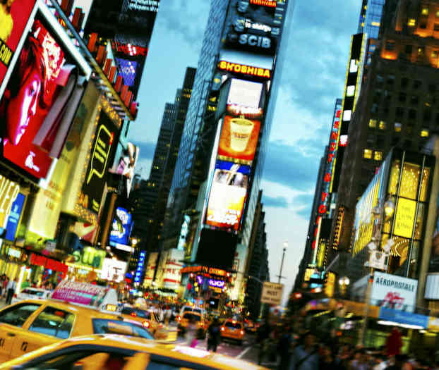 Trafikkert gate med taxibiler og reklamekledde bygninger i en bymiljø. (AI-generert tekst)