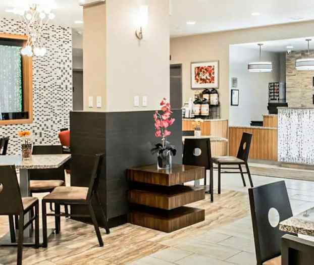 En hotellobby med sitteplasser, dekorasjoner og resepsjonsområde. (AI-generert tekst)