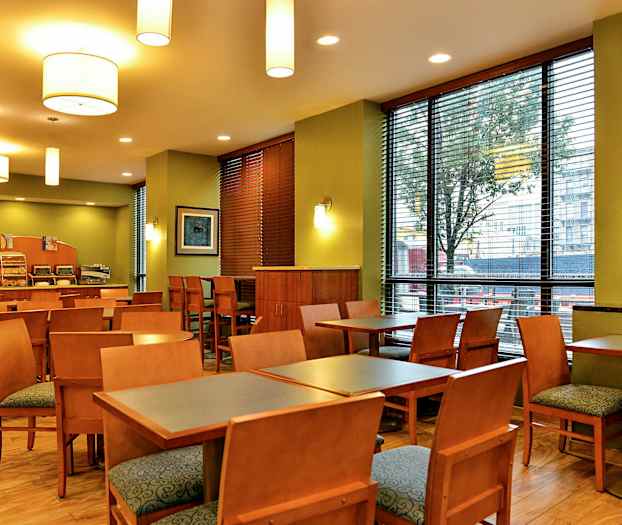 En restaurant med bord, stoler og en serveringsdisk. (AI-generert tekst)