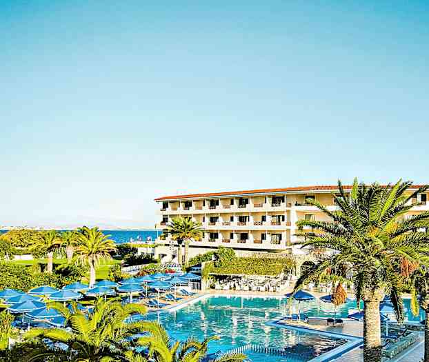 Hotellbygning med flere etasjer omgitt av palmer og et stort basseng. (AI-generert tekst)