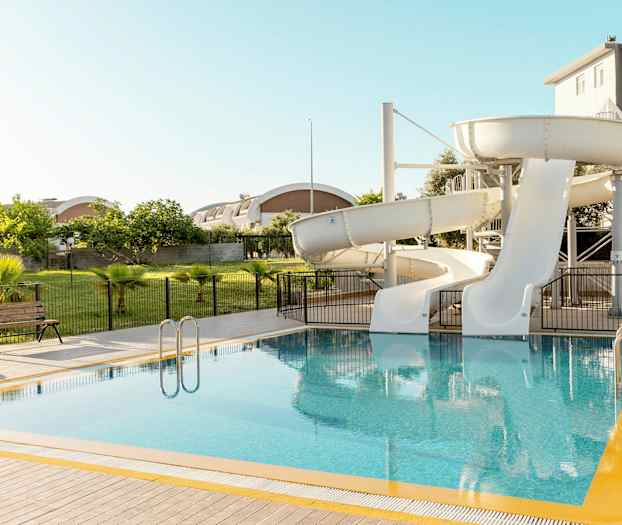 Et basseng med to hvite vannsklier. (AI-generert tekst)