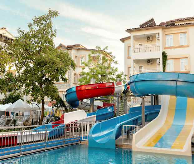 Bilde av en vannpark med vannsklier og bygninger i bakgrunnen. (AI-generert tekst)