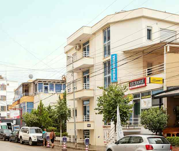 Gate med parkerte biler og bygninger med skilt. (AI-generert tekst)