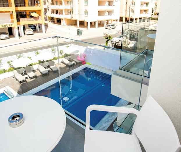 Balkong med utsikt over et svømmebasseng og nabobygg. (AI-generert tekst)