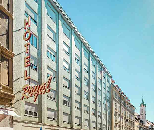 Bilde av en bygate med hotellfasade og bygninger rundt. (AI-generert tekst)