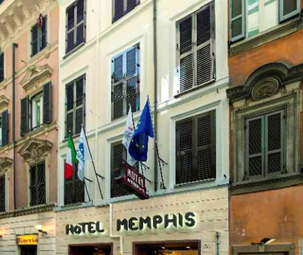 Fasaden til Hotel Memphis med inngang i gateplan og flagg synlige over. (AI-generert tekst)