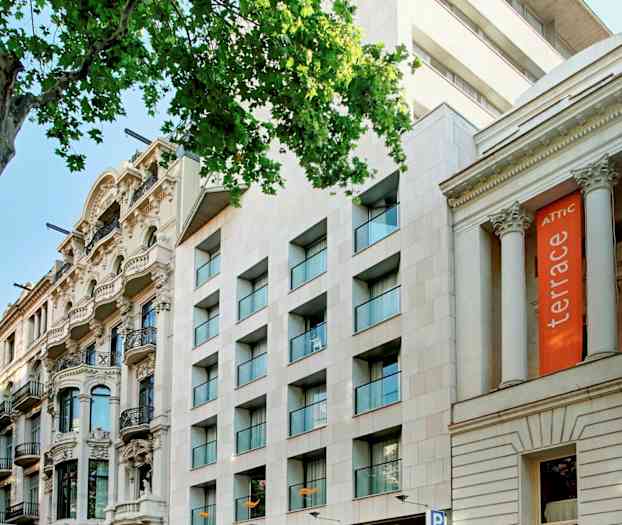 En gate med flere bygninger, inkludert et hotell med skiltet "Citadines" og andre arkitektoniske stiler. (AI-generert tekst)