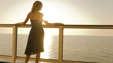 En dame ser utover havet fra et cruiseskip