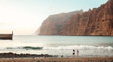 Strand på Tenerife med Los Gigantesi bakgrunnen