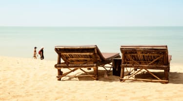 Solstoler på en strand i Thailand