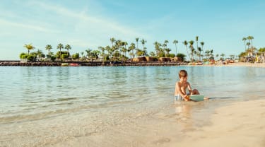 Gutt leker ved strandkanten