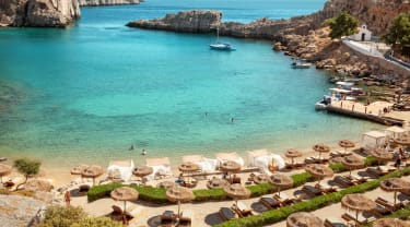 Strand med solstoler i Londos, Hellas