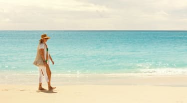 Kvinne går på stranden i Aruba
