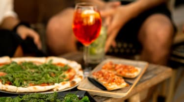 Pizza og et glass med vin på et bord