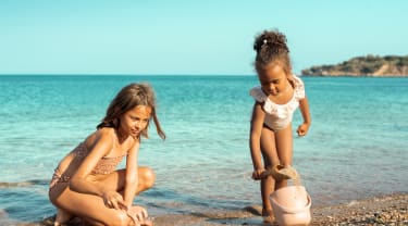To jenter leker på en strand