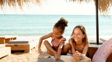 To jenter slapper av på stranden