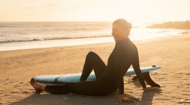 Surfer slapper av på strand