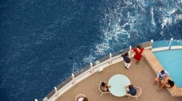 Mennesker nyter dekket utendørs på et cruiseskip