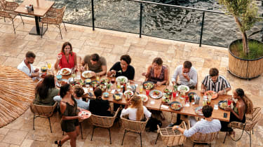 Gruppe sitter samlet til måltid ved langbord