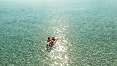 Et par som koser seg og bader i havet