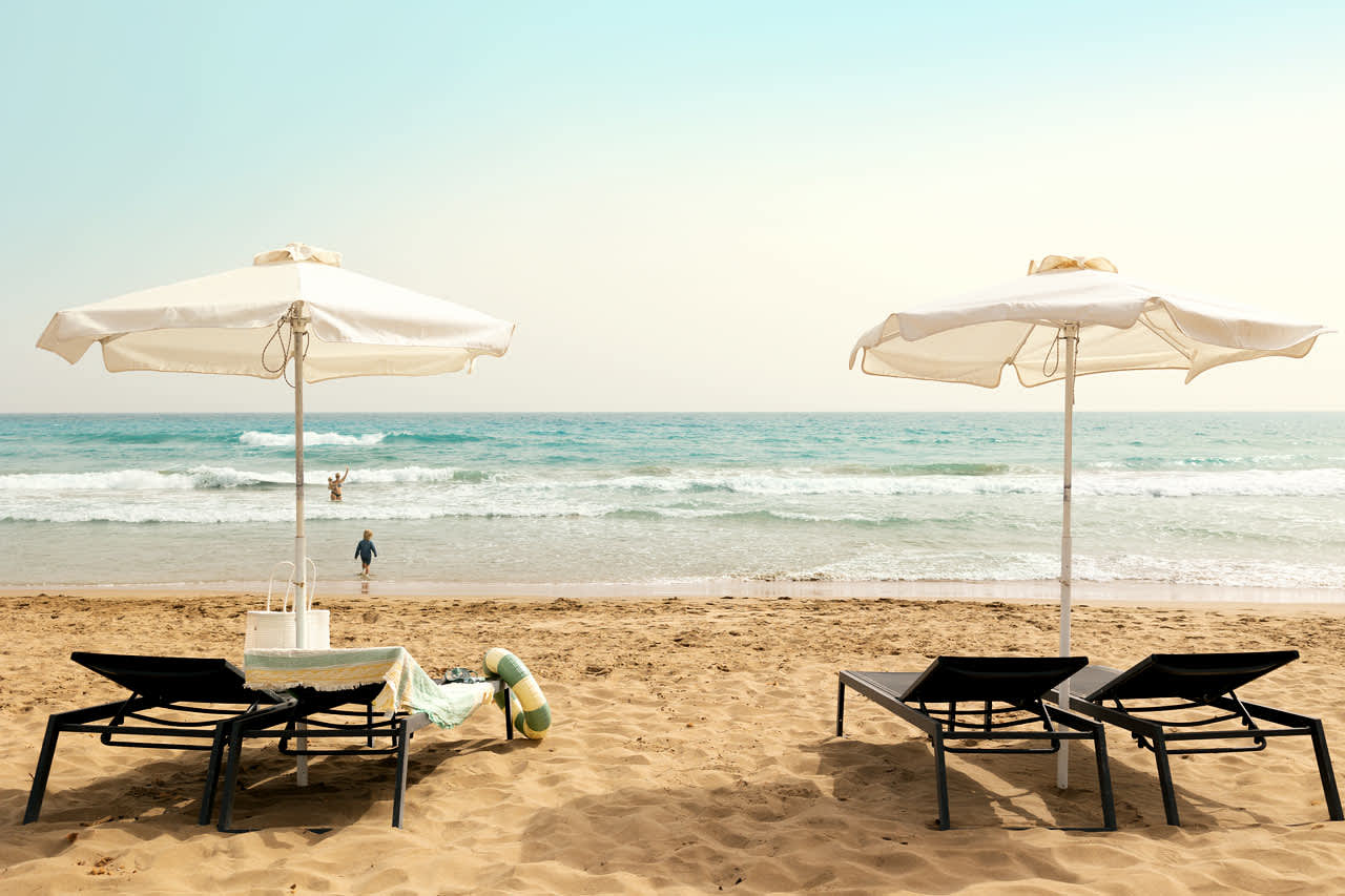 På stranden nedenfor hotellet kan du leie solsenger og parasoller