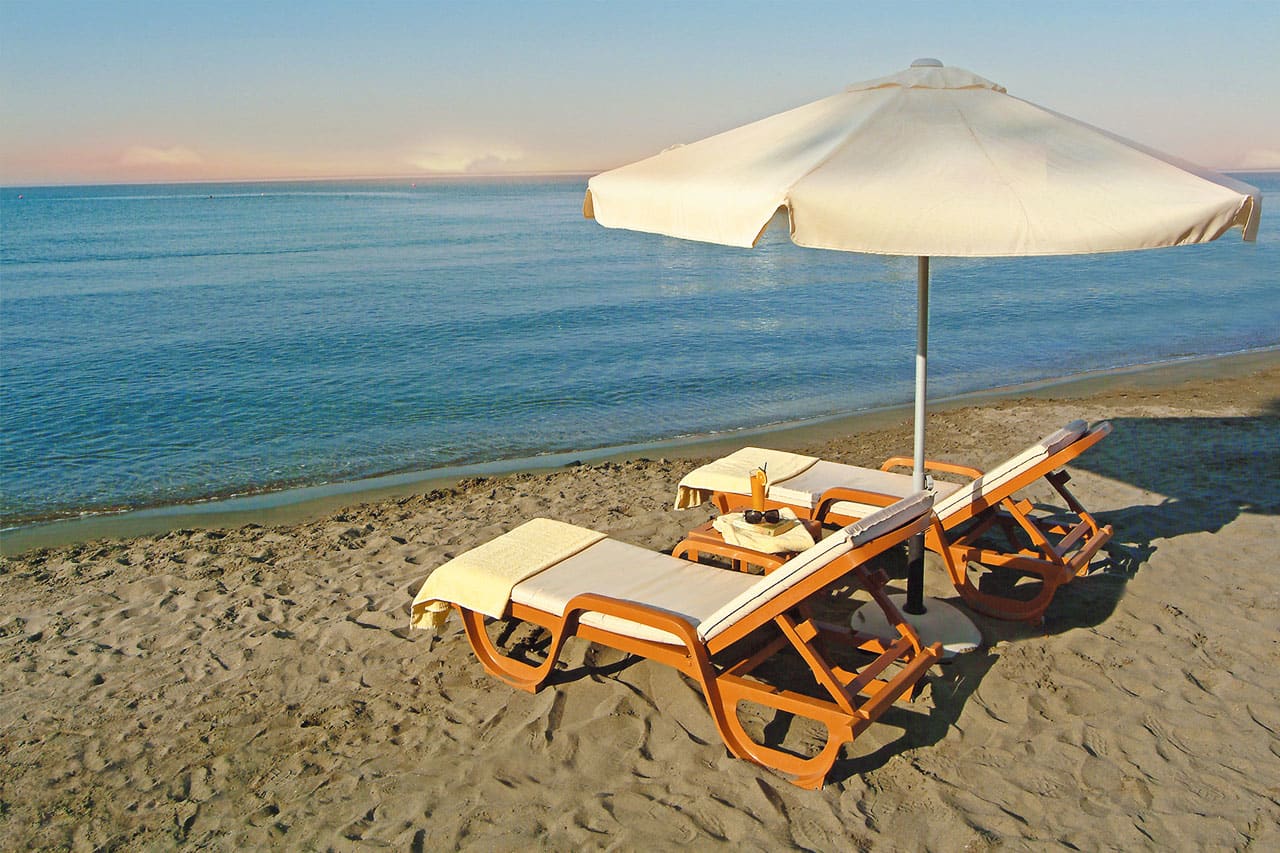 Solsenger med madrasser og parasoller kan lånes på stranden