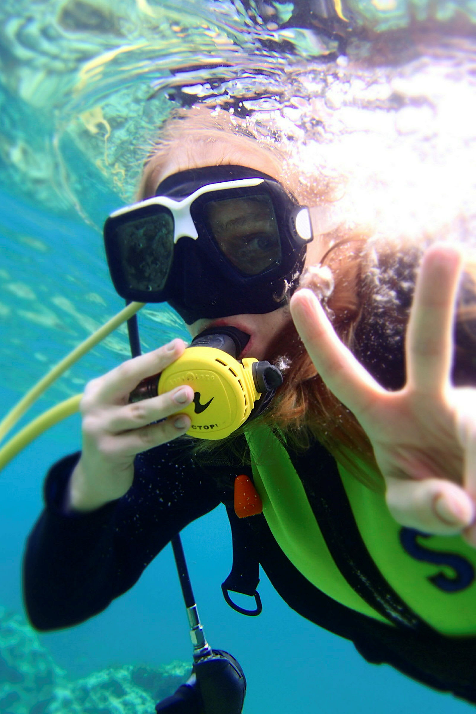 Person som snorkler under vann og viser et fredstegn. (AI-generert tekst)