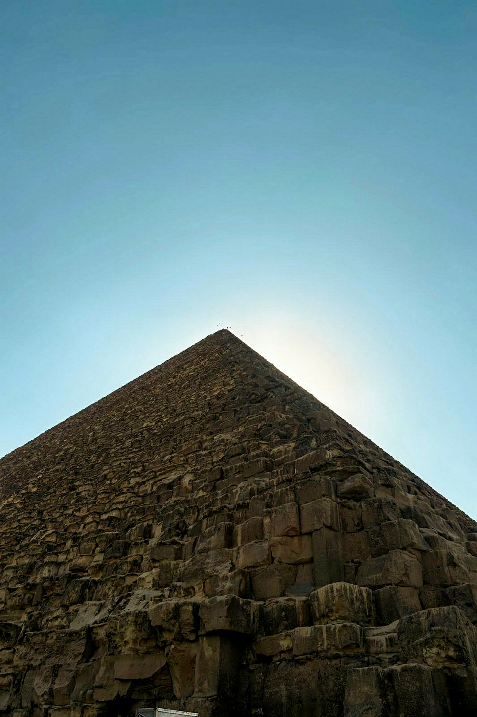 En steinpyramide som strekker seg oppover mot en klar himmel. (AI-generert tekst)