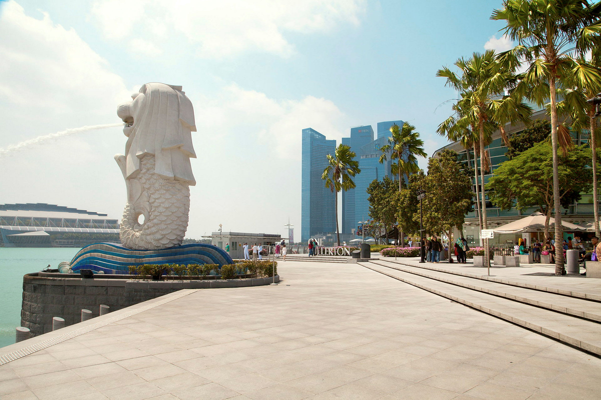 Bilde av Merlion-statuen i Singapore med fontene, omgitt av moderne arkitektur og palmer. (AI-generert tekst)