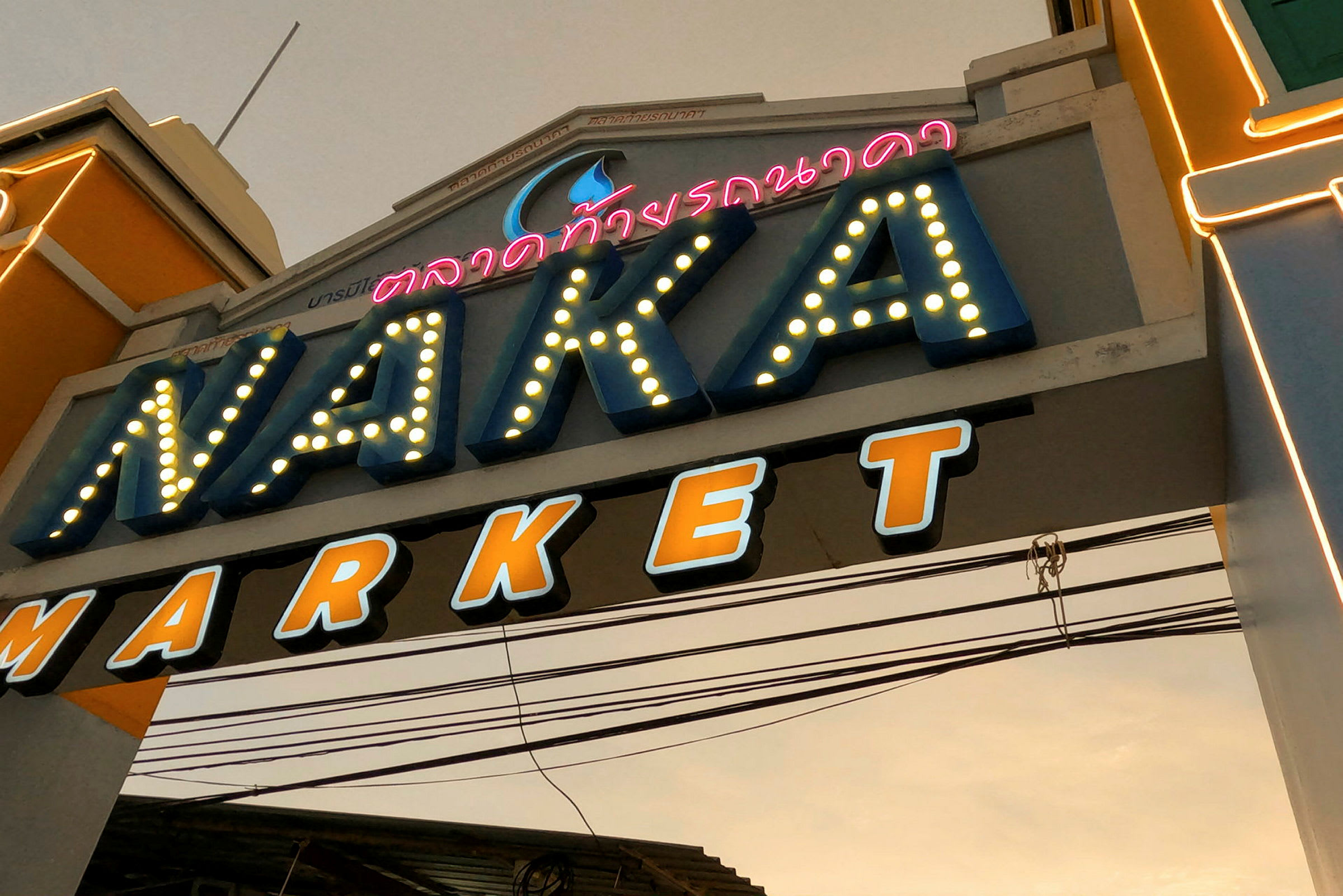 Inngangen til Naka Market med belysning og merking. (AI-generert tekst)