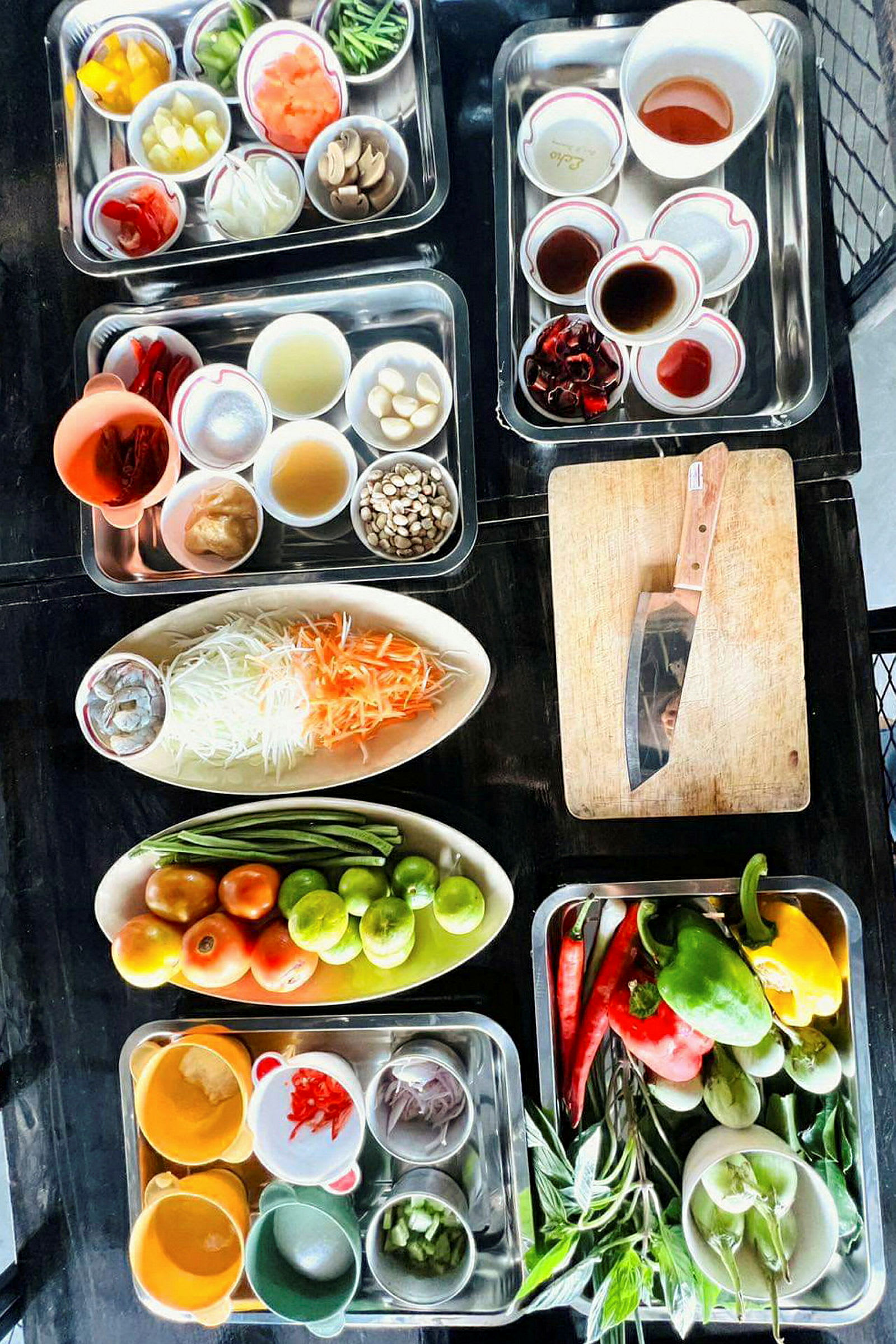 Ulike grønnsaker, krydder og ingredienser arrangert i skåler og fat på et bord. (AI-generert tekst)