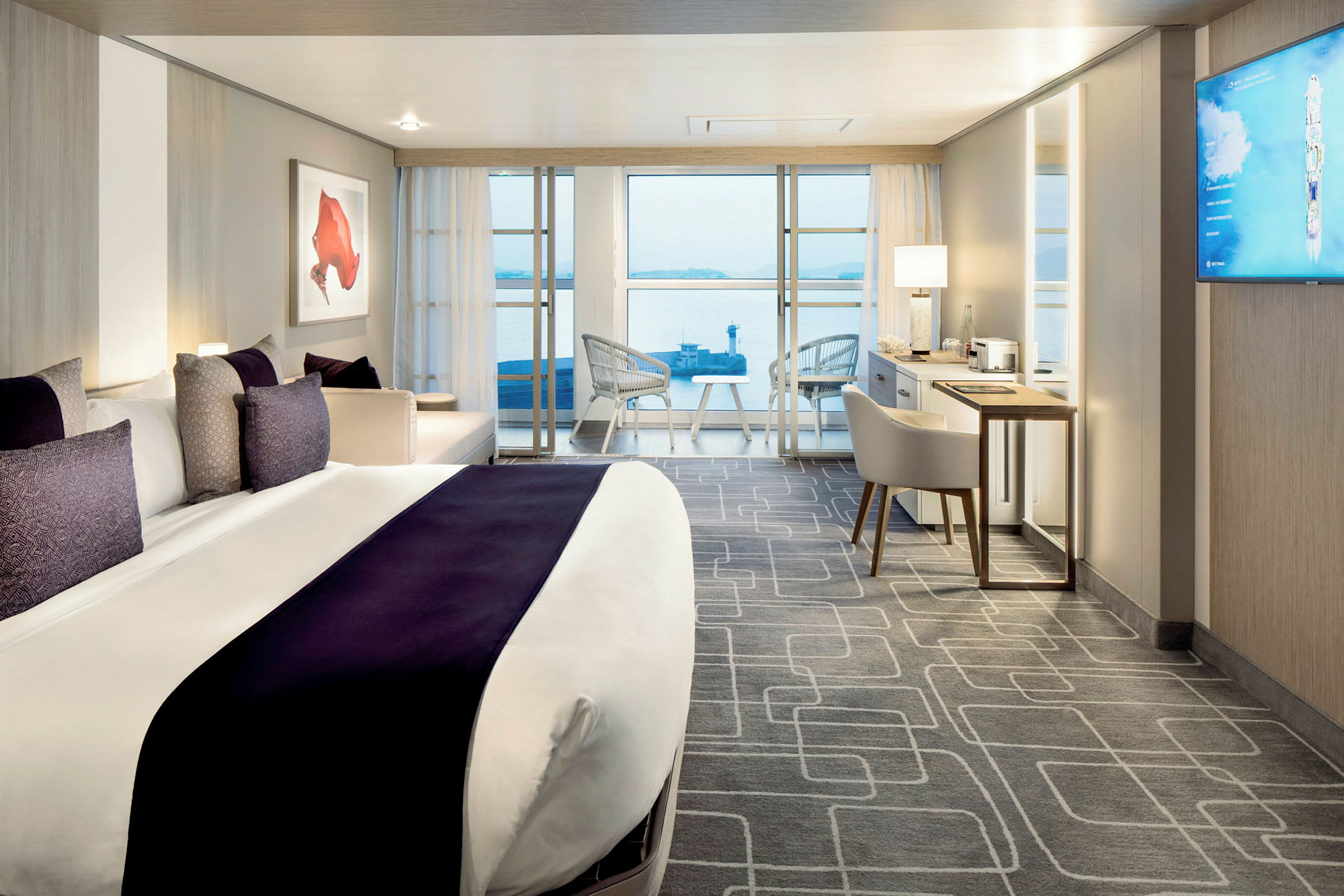 Moderne hotellrom med en stor seng, sitteområde og utsikt mot havet. (AI-generert tekst)