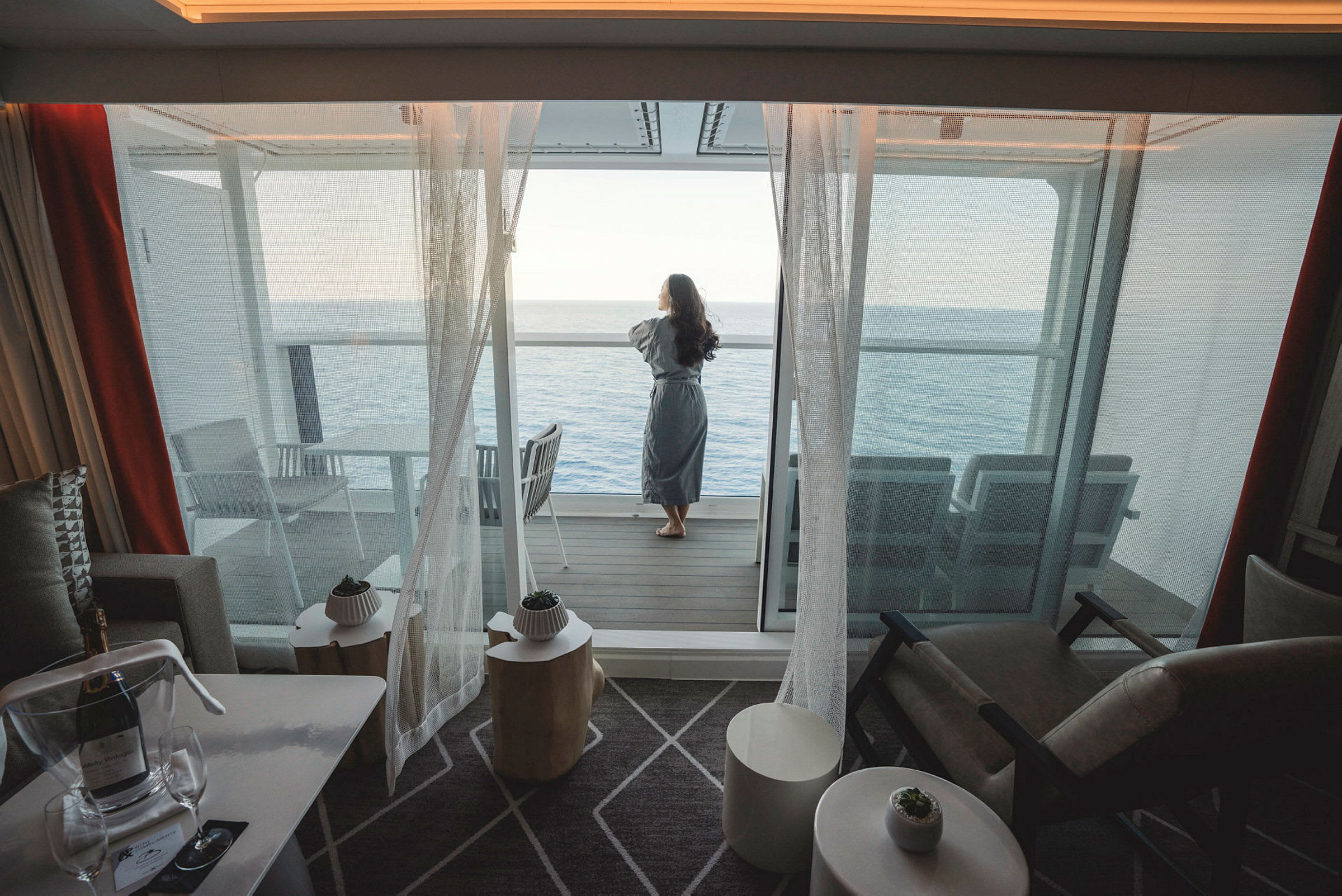 En person står på en balkong og ser ut over havet. (AI-generert tekst)