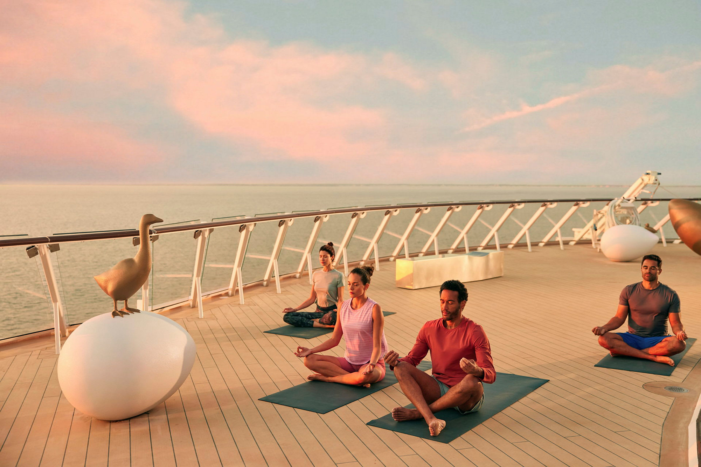 Personer som driver yoga på et cruiseskip, ved sjøen under solnedgang. (AI-generert tekst)