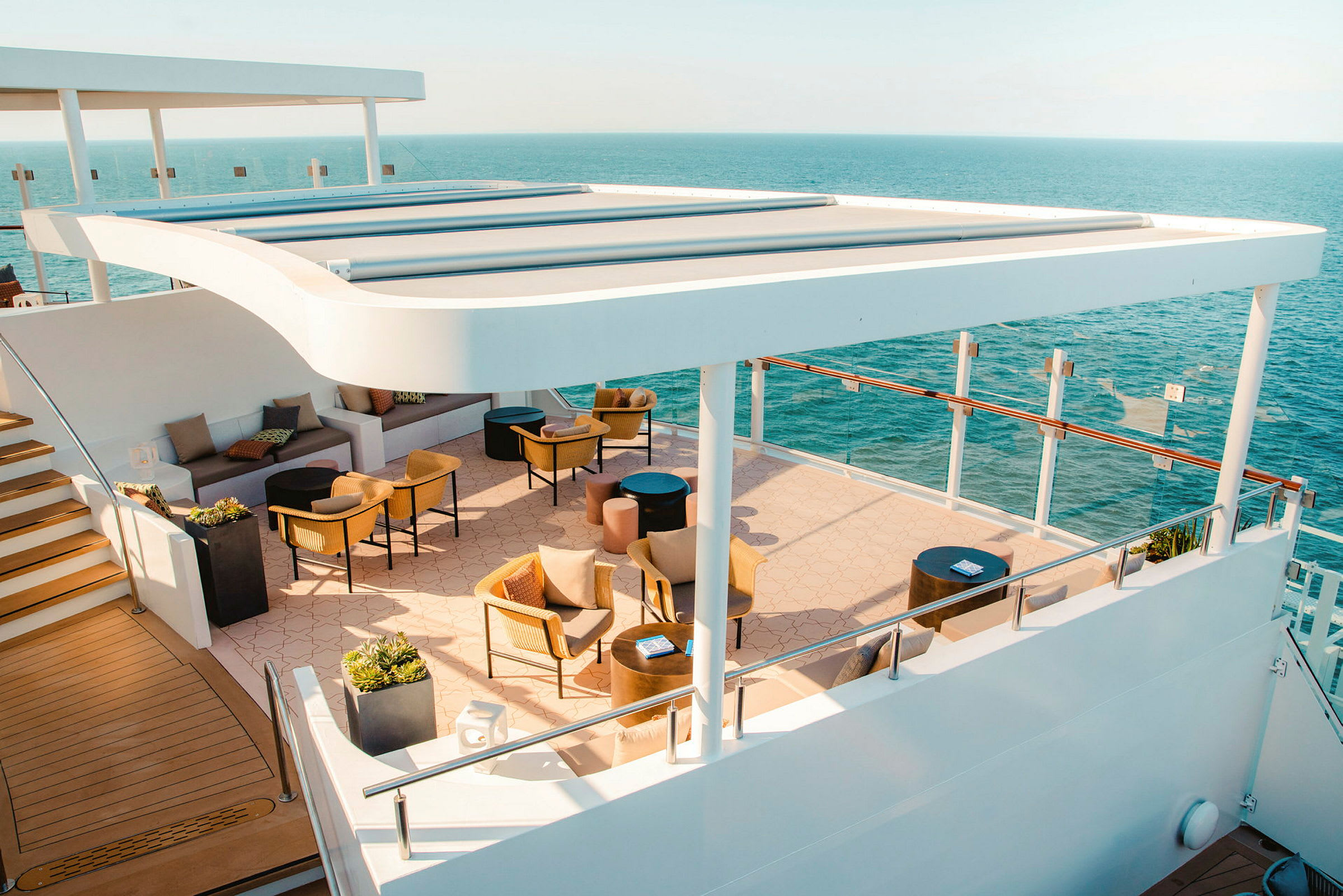 Terrasse på et skip med sittegrupper og utsikt over havet. (AI-generert tekst)