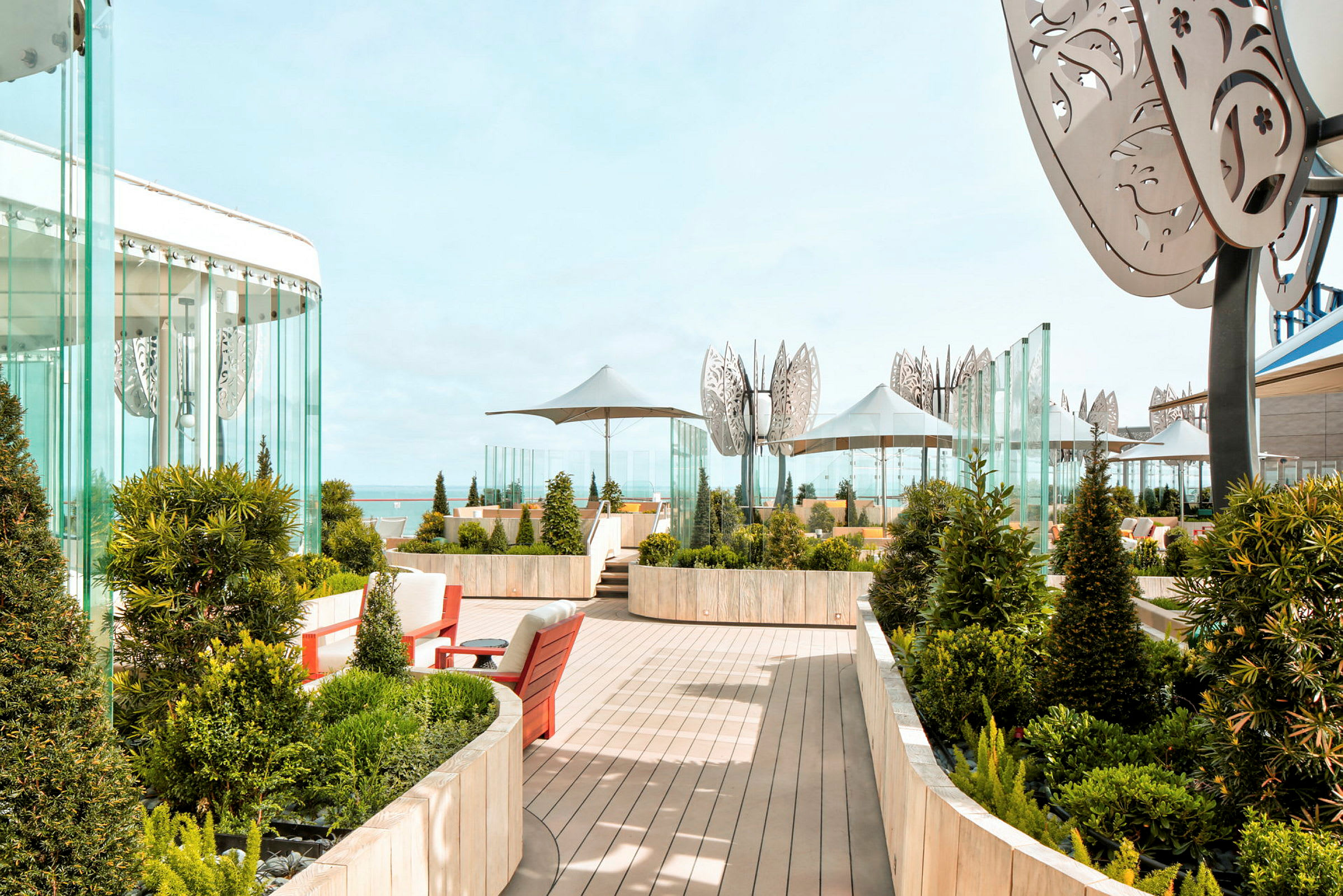 En terrasse med planter, sitteplasser og utsikt mot havet. (AI-generert tekst)