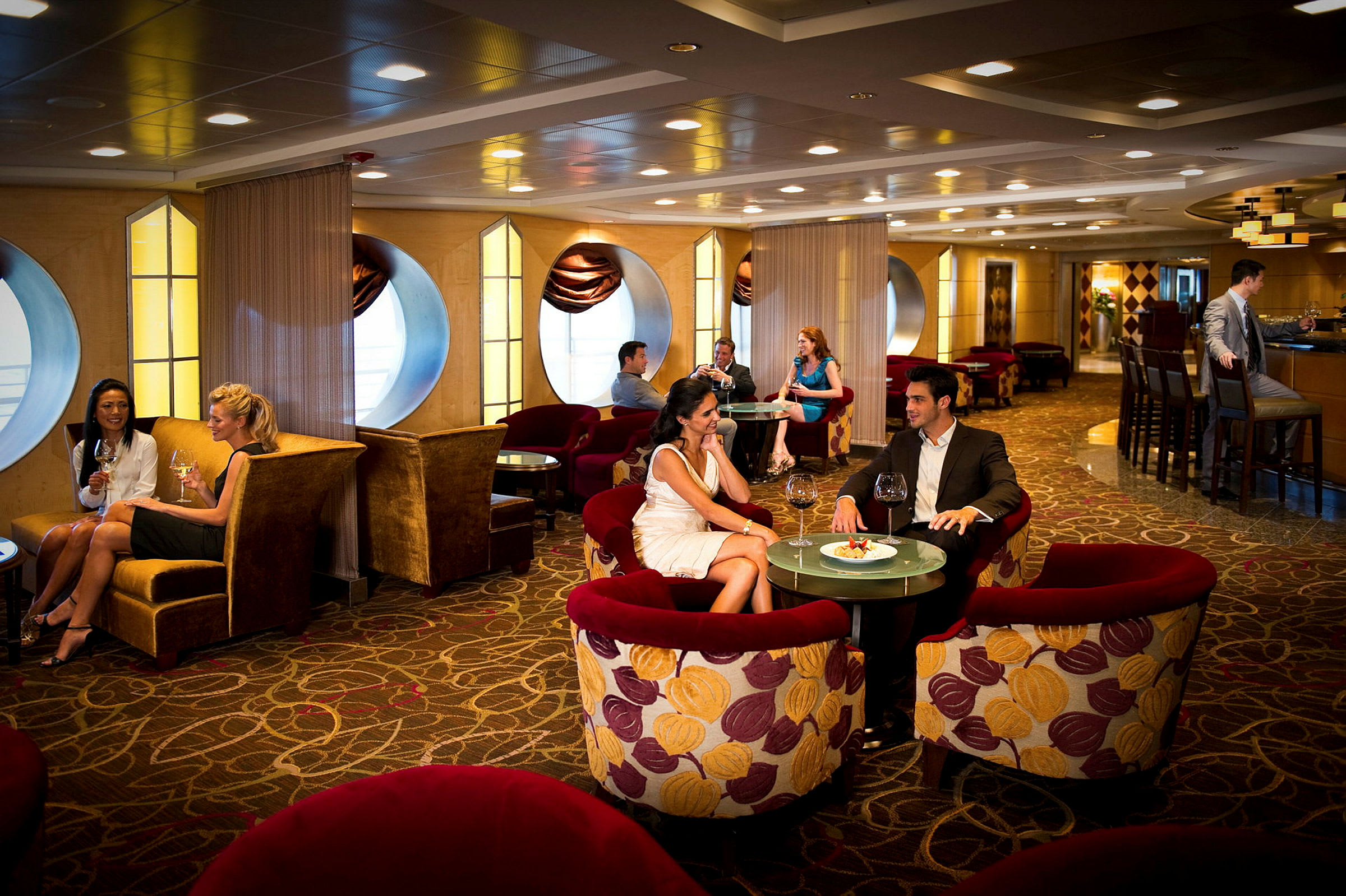 En elegant lounge med personer som sitter ved bord og nyter mat og drikke. (AI-generert tekst)
