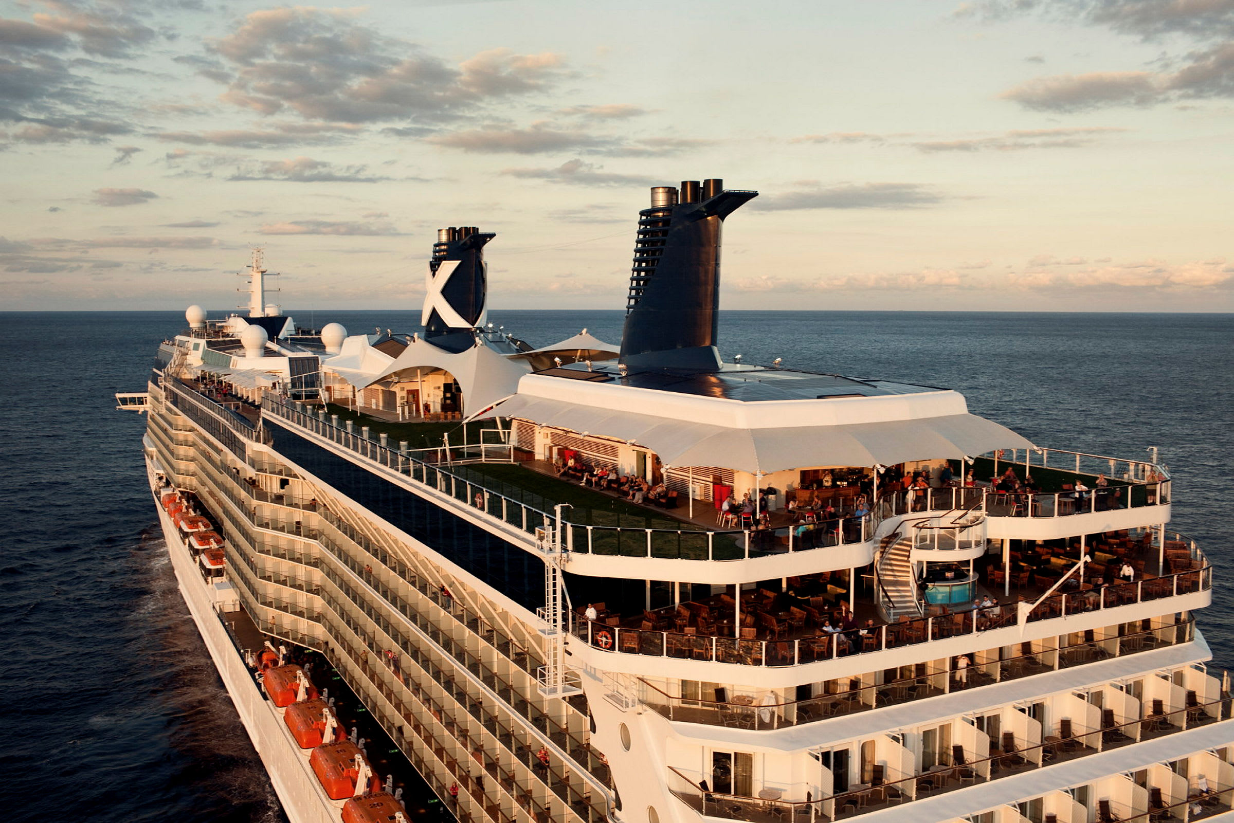 Bilde av et cruiseskip på havet, med flere etasjer og utendørs områder. (AI-generert tekst)