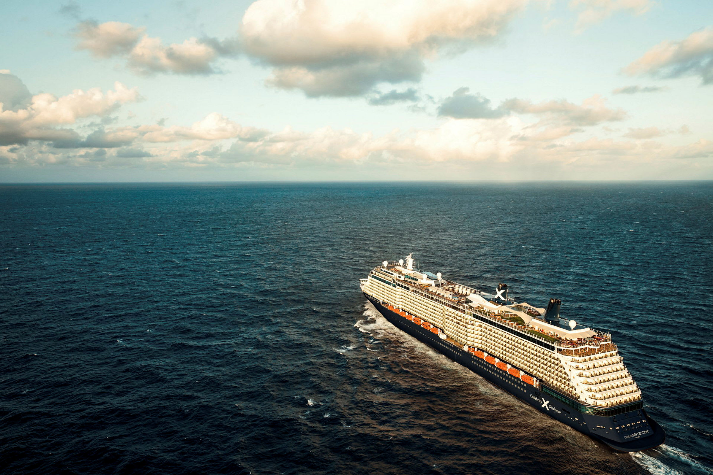 Et stort cruiseskip seiler på åpent hav under en himmel med skyer. (AI-generert tekst)