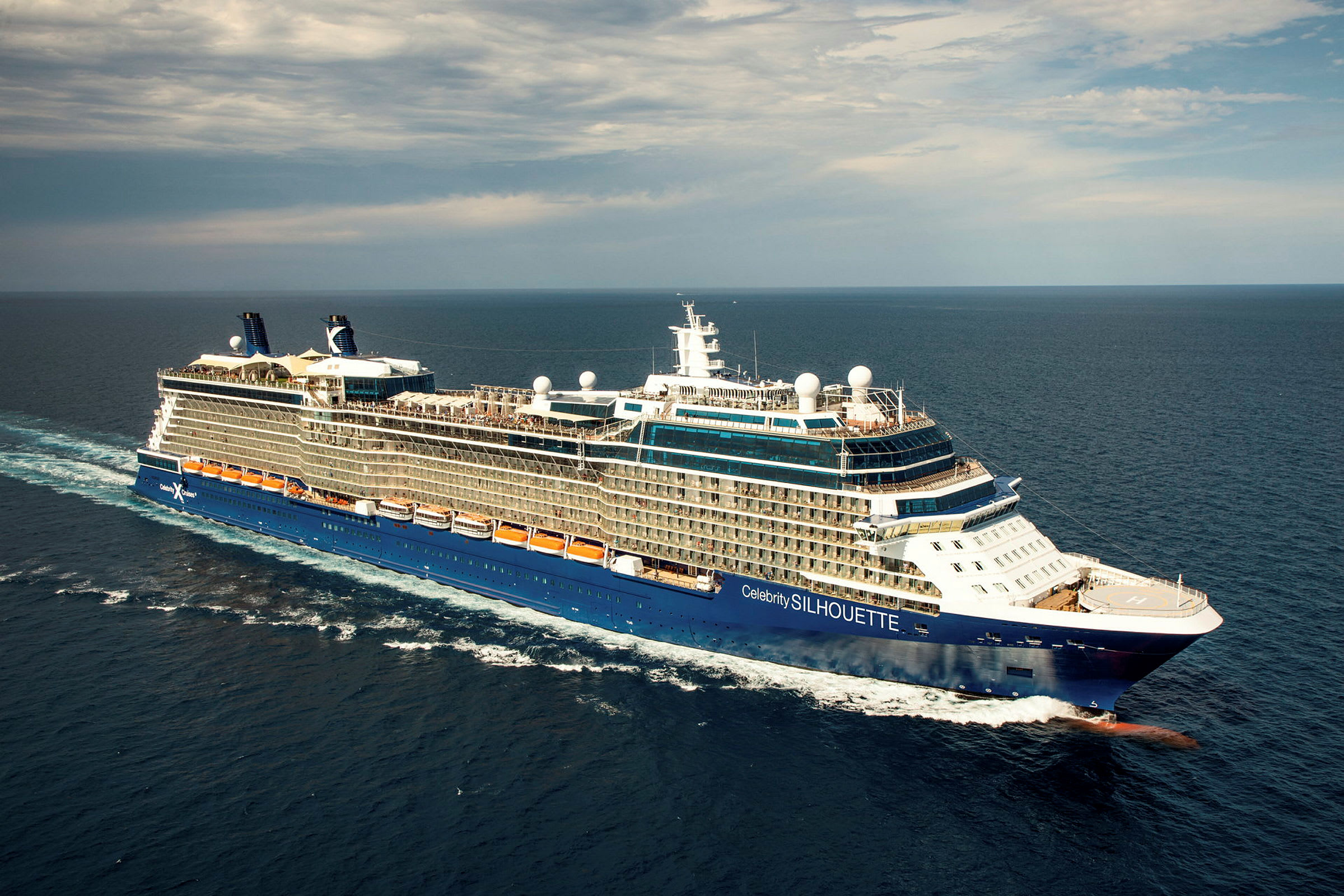 Et stort cruiseskip på åpent hav med blått skrog og flere dekk. (AI-generert tekst)