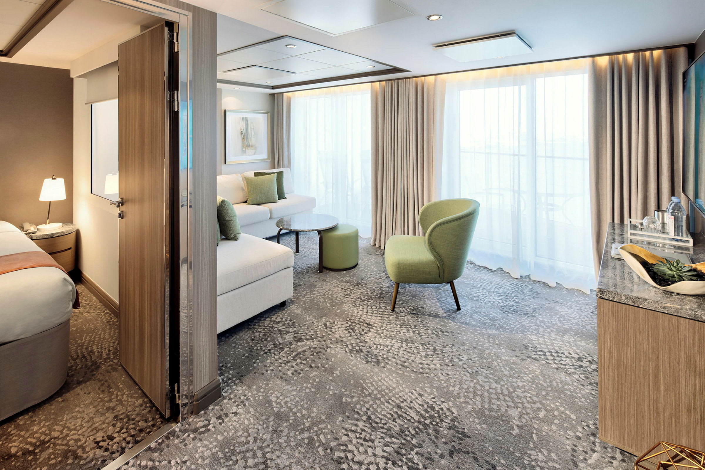 Hotellrom med åpent område, sofa, lenestol og store vinduer. (AI-generert tekst)