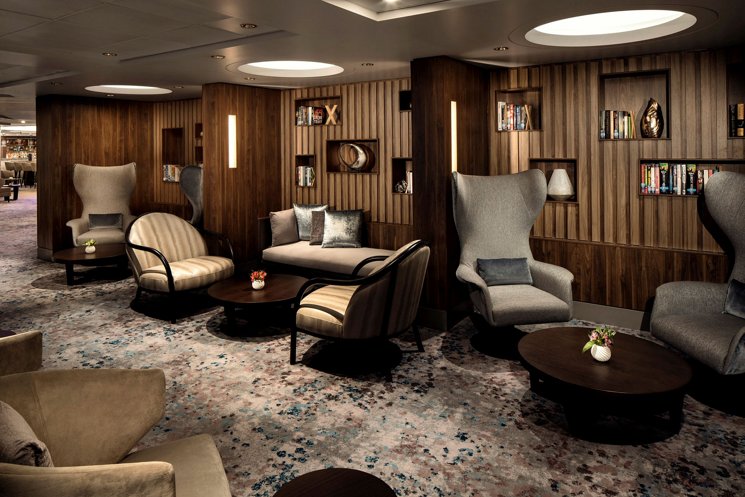 En elegant lounge med sittegrupper og bokhyller. (AI-generert tekst)