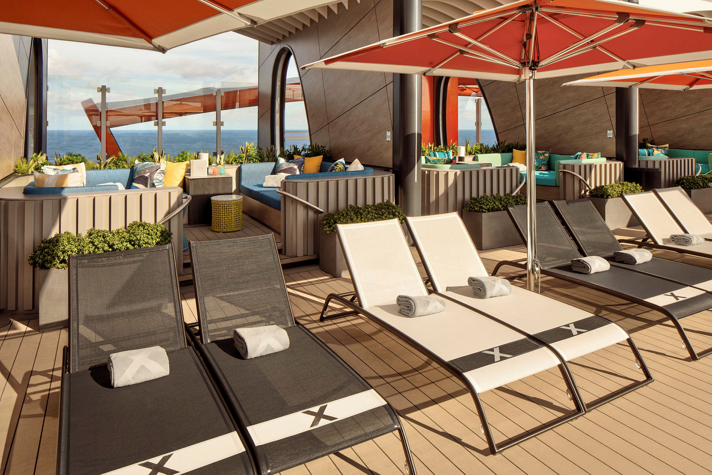 Bilde av en solterrasse med solsenger, parasoller og sittegrupper med havutsikt. (AI-generert tekst)